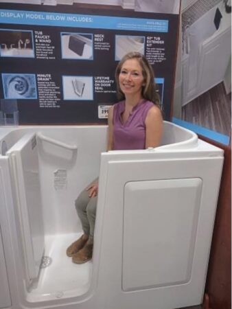 A woman sits in one of the best walk-in tubs display model to test the size