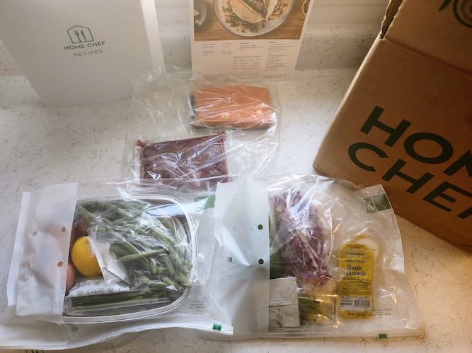 The various ingredients of a Home Chef box displayed, including vegetables and herbs