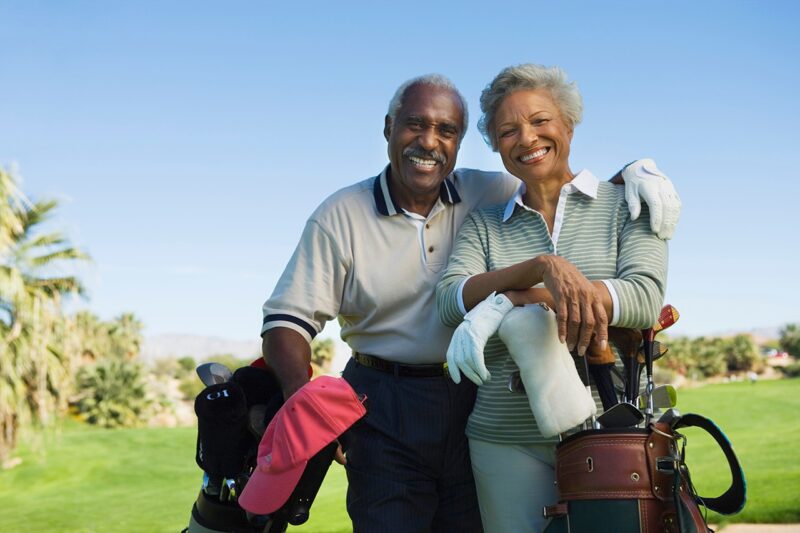 Portrait of happy senior couple in golf course smiling