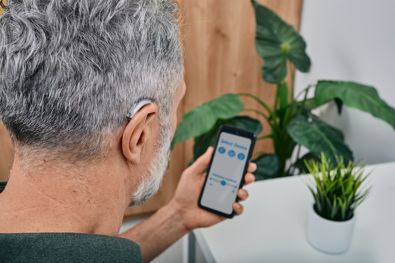 Senior man with hearing aids using hearing aids smartphone app MDHearing review