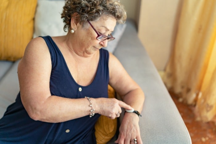 Older adult woman using a medical alert bracelet