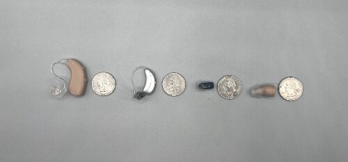 Hearing aids beside coins