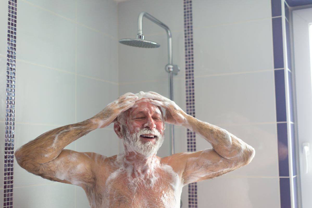 Smiling older adult man in shower
