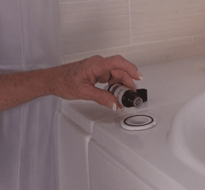 person adding essential oil to Safe Step walk in tub aromatherapy capsule