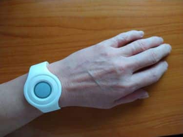 White help button bracelet displayed on wrist.