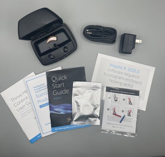 Evolv AI hearing aids with a black charger and additional tools and informational booklets