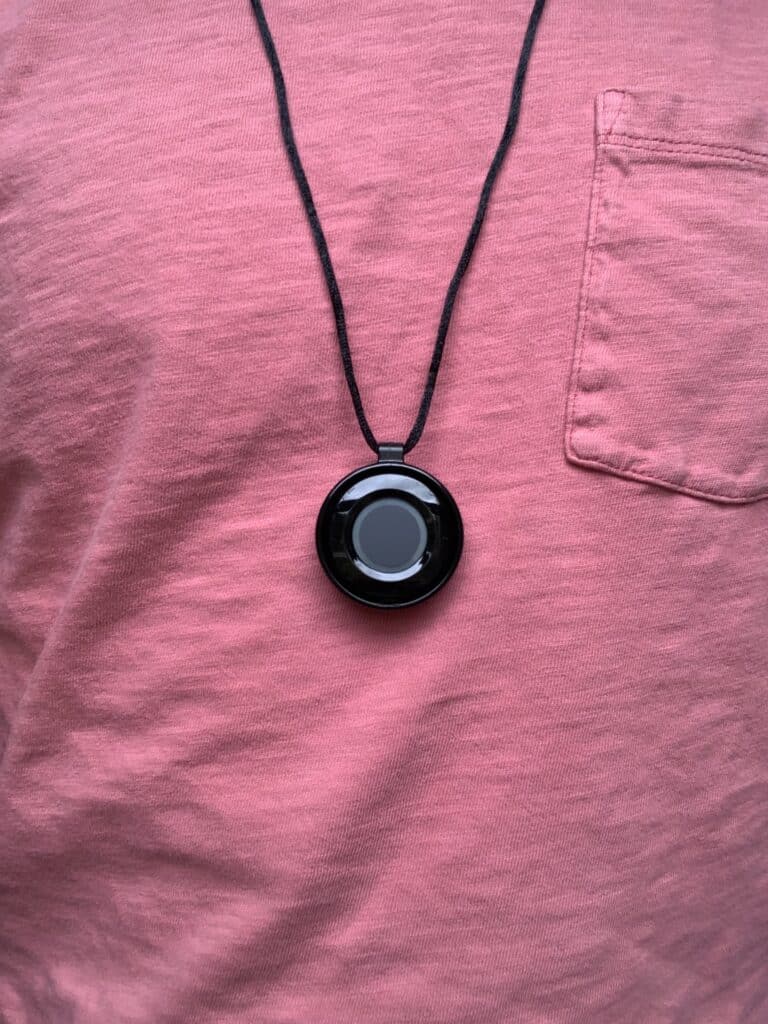 Medical alert user wearing help button necklace against a pink shirt