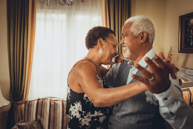 Older couple smiling and dancing.