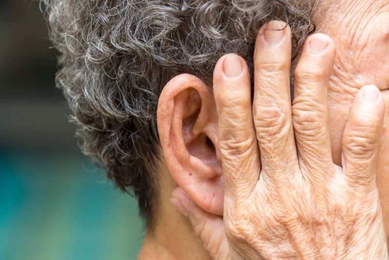 Older person holding ear