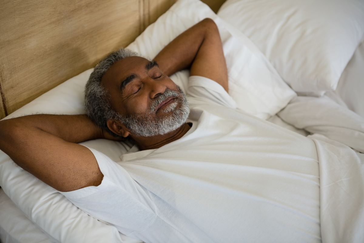 Older man reclining on adjustable bed at home