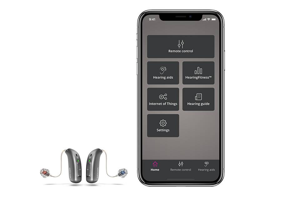 Oticon ON App menu page displayed on a cellphone next to a pair of Oticon hearing aids