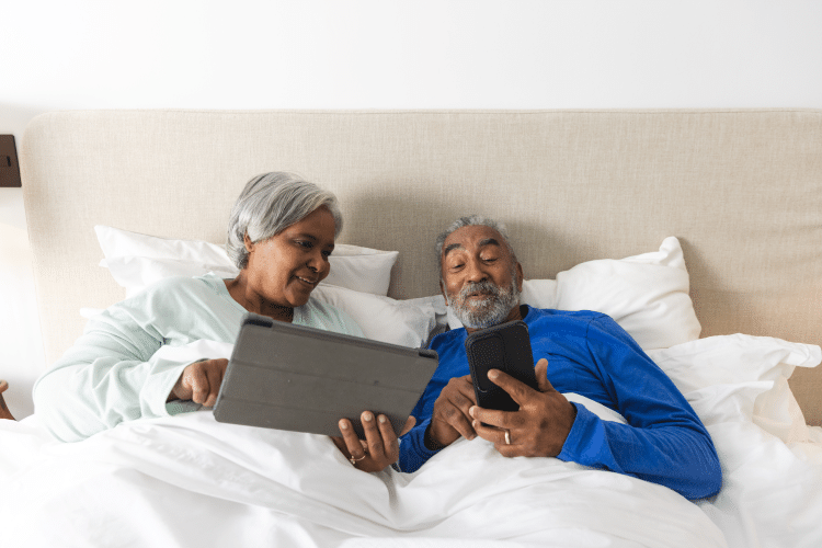 happy older couple sitting in bed