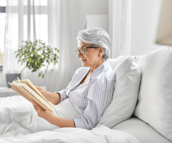 Older woman sitting in bed reading
