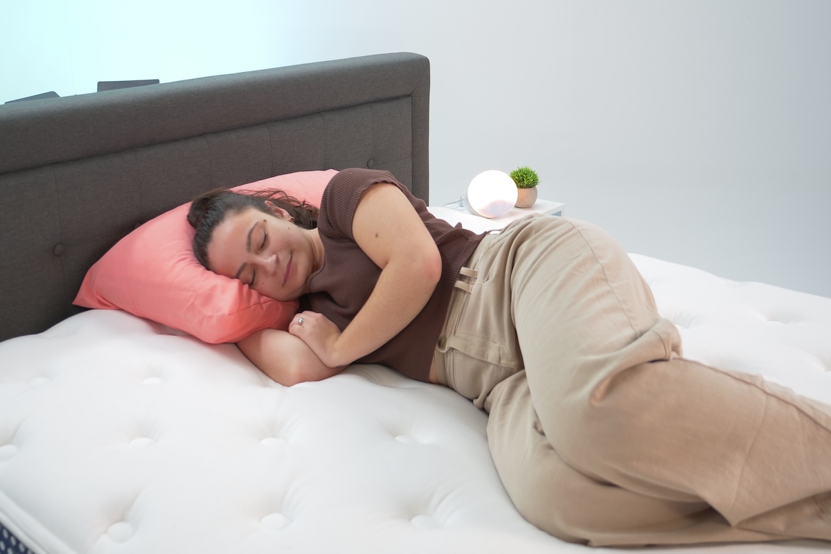 : Woman sleeping on her side on the WinkBed mattress