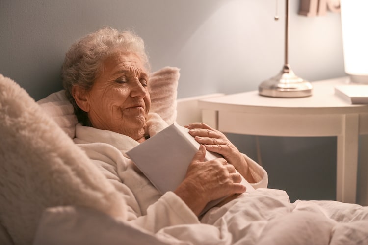 Older woman sleeping with book in her hands