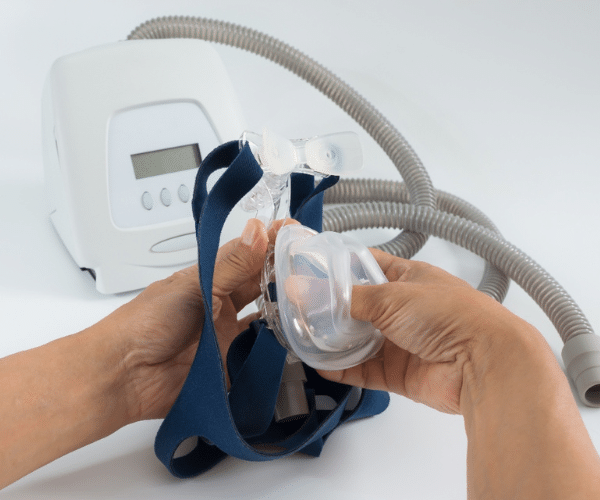Image of hands holding a CPAP machine