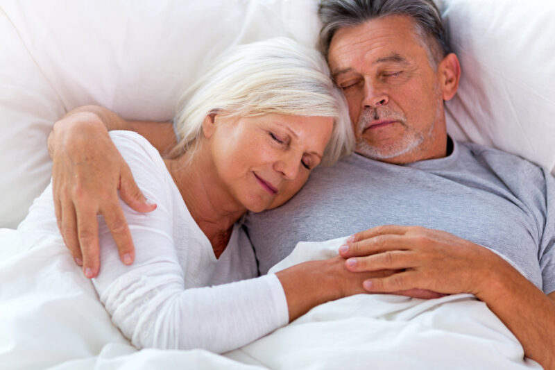 older couple asleep in bed at home