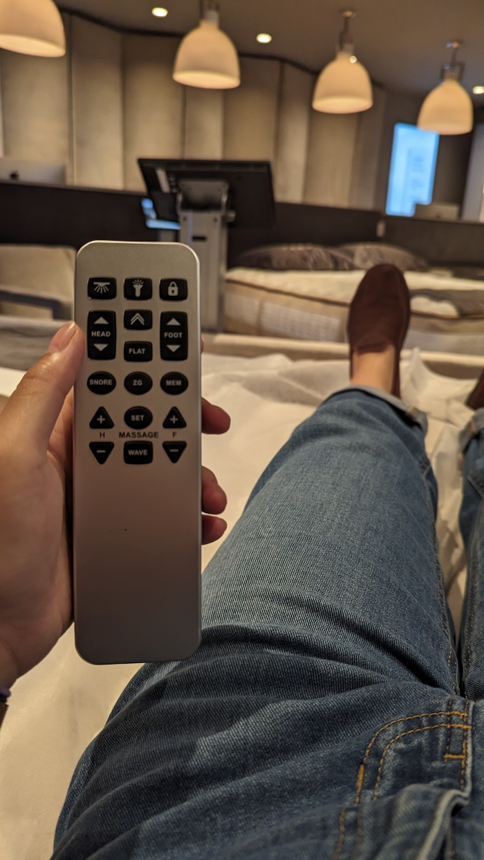 Person laying on adjustable bed holding its remote