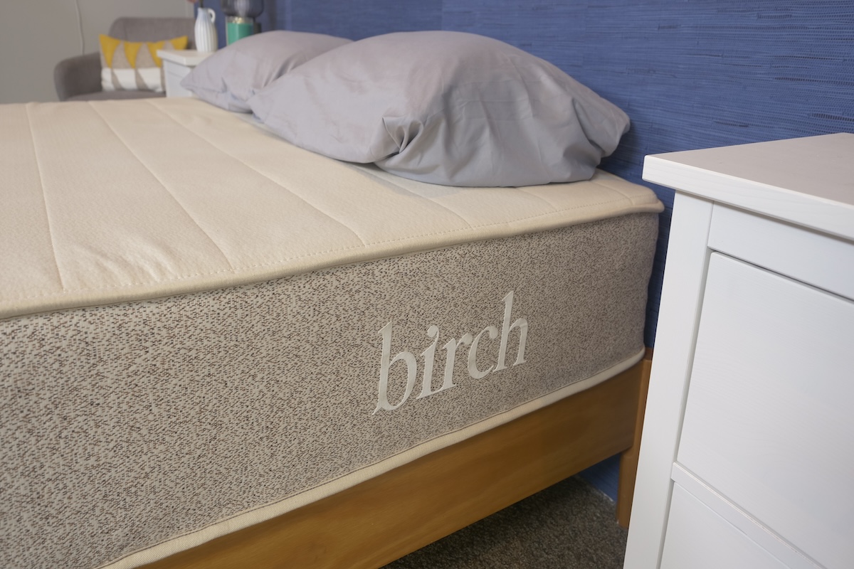 Birch Natural Mattress next to a white bedside table with gray pillows