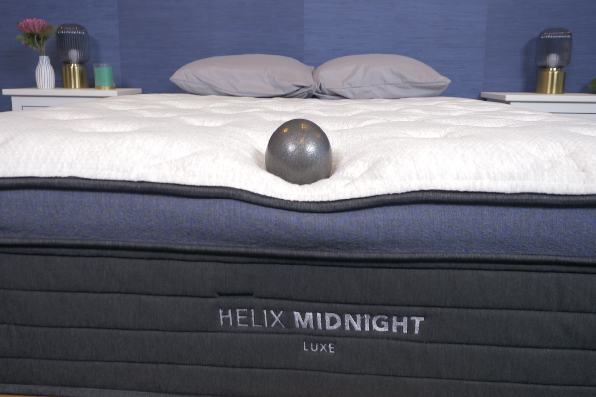 A 10-pound ball sinking into the surface of the Helix Midnight Luxe mattress