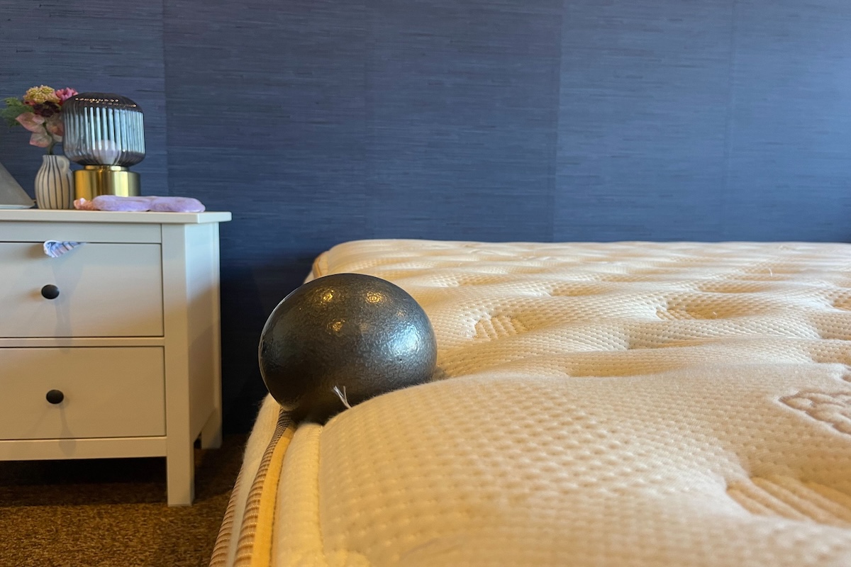 Bowling ball sitting on the edge of the mattress 