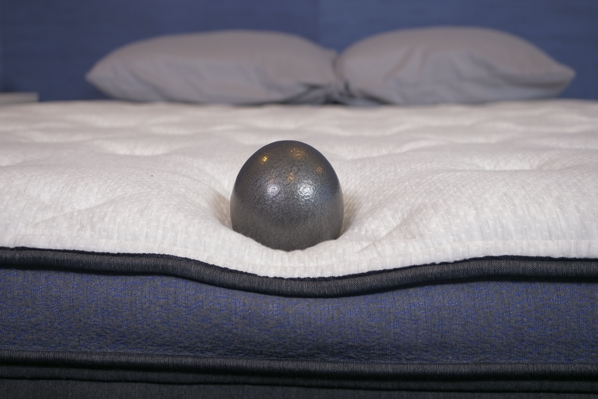 A 10-pound ball resting on the Titan Plus mattress